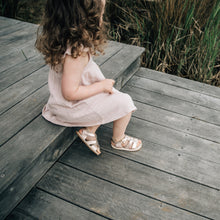 toddler girl wearing rose gold sandals and pink dress