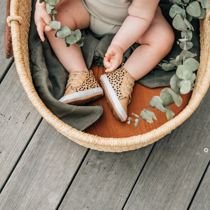 baby in a basket wearing prewalker boots