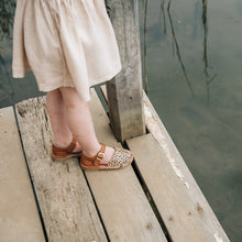 Girl weather leather espadrille sandal standing on a pier.